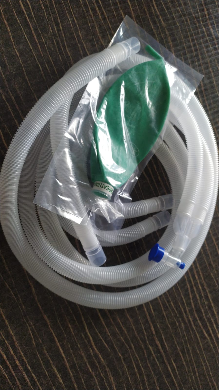 Anaesthetic breathing circuit coiled with a green breathing bag